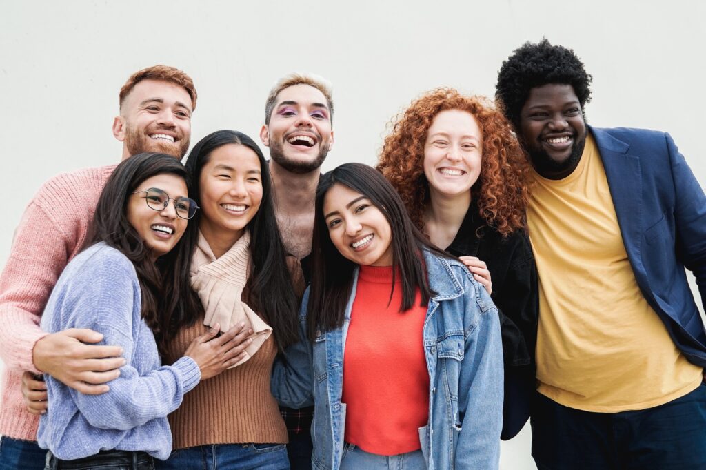 Diverse group of friends having fun smiling at camera outdoor. Young people celebrate together